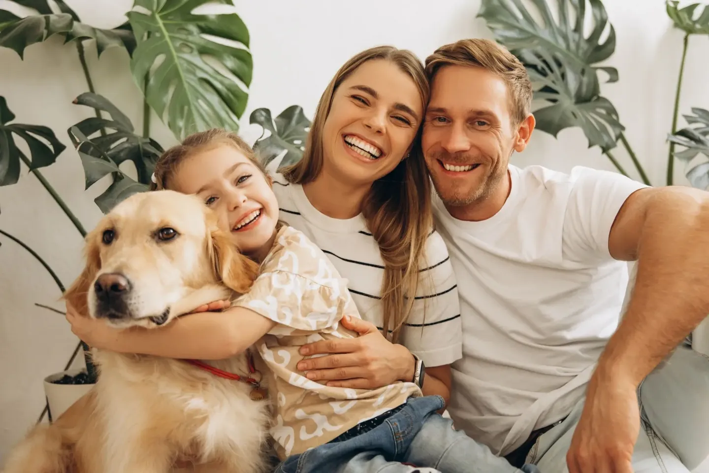 Happy family with their dog smiling together at home.